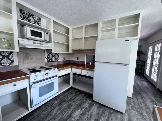 a kitchen with cabinets stainless steel appliances and wooden floor