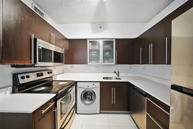 a kitchen with stainless steel appliances kitchen island granite countertop a sink and cabinets