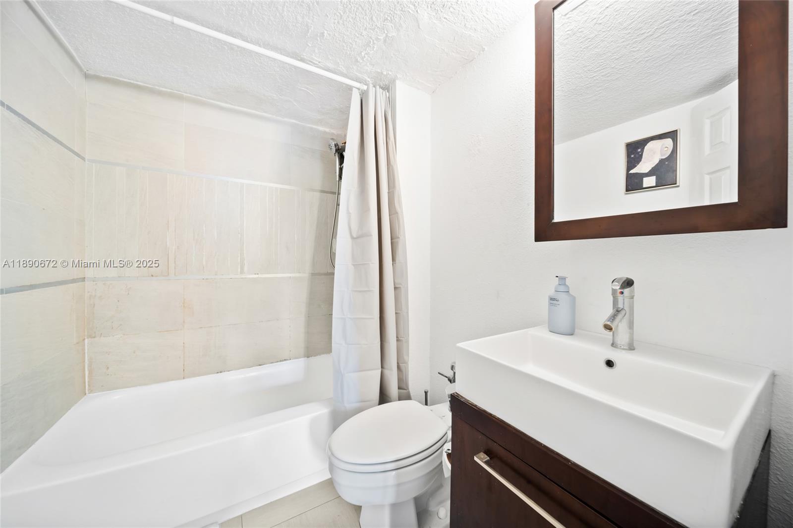 1500 Bay Road, Unit 1228S Miami Beach, FL 33139 - Photo 19 of 35 a bathroom with a sink a toilet and a bathtub