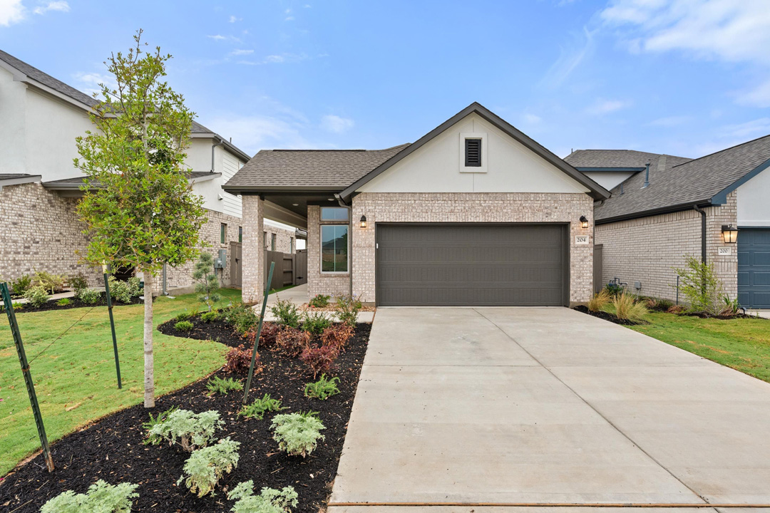 204 Bloomington Loop Hutto, TX 78634 - Photo 1 of 37 a front view of a house with a yard and garage