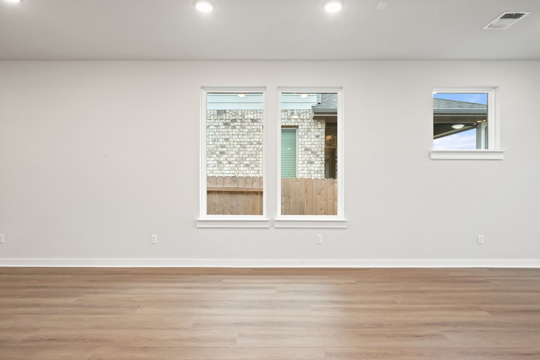 204 Bloomington Loop Hutto, TX 78634 - Photo 11 of 37 a view of an empty room with wooden floor and a window