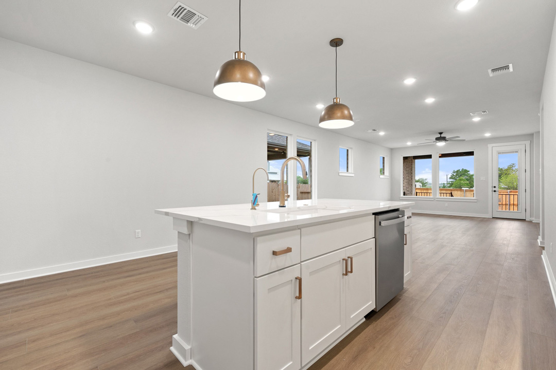 204 Bloomington Loop Hutto, TX 78634 - Photo 16 of 37 a kitchen with a sink chandelier and wooden floor