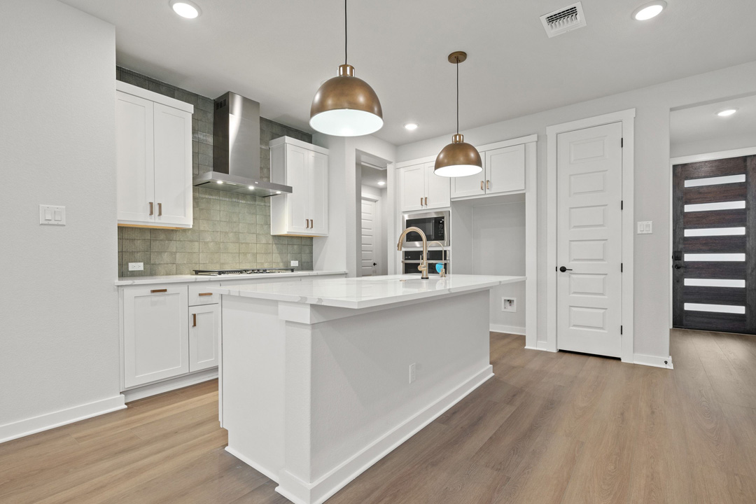 204 Bloomington Loop Hutto, TX 78634 - Photo 19 of 37 a kitchen with kitchen island white cabinets and refrigerator
