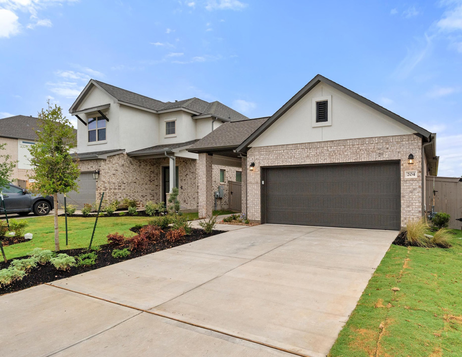 204 Bloomington Loop Hutto, TX 78634 - Photo 2 of 37 a front view of a house with a yard and garage