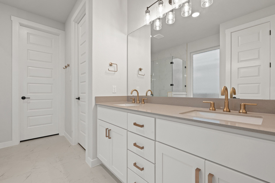 204 Bloomington Loop Hutto, TX 78634 - Photo 25 of 37 a bathroom with a granite countertop sink a large mirror and a shower