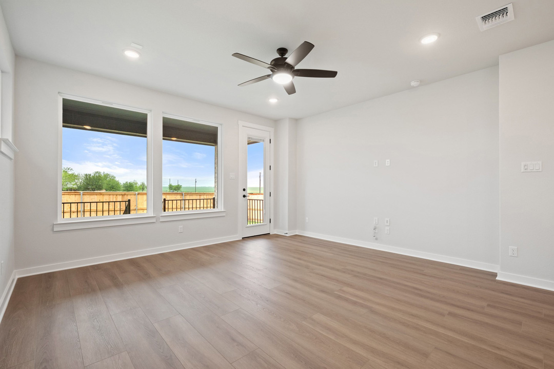 204 Bloomington Loop Hutto, TX 78634 - Photo 10 of 37 a view of an empty room with wooden floor and a window