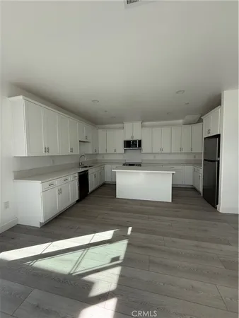 a large kitchen with cabinets and wooden floor