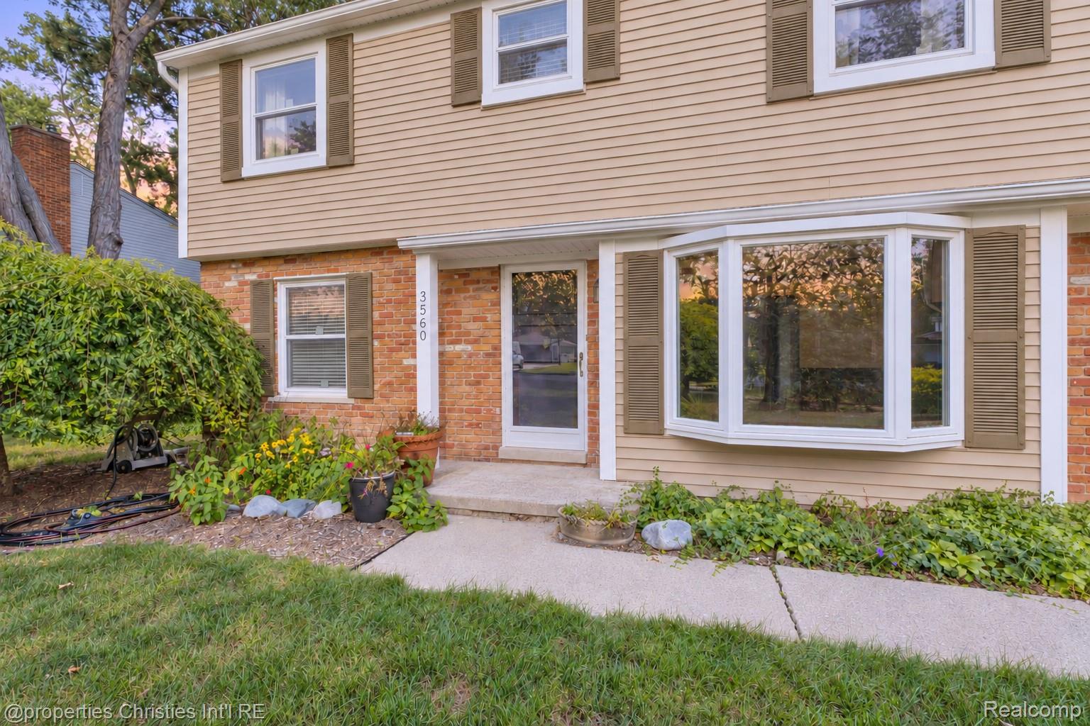 3560 Beach Road Troy, MI 48084 - Photo 2 of 40 Welcoming front elevation featuring brick and horizontal siding exterior, multi-pane windows, and a bay window accent
