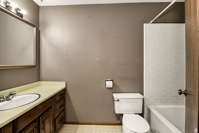299 West Center Street, Unit 2 Logan, UT 84321 - Photo 26 of 46 Bathroom featuring a wood-finish vanity with an integrated sink, a large wall-mounted mirror, a tiled shower-tub combination, and patterned floor tiling