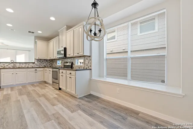 a kitchen with granite countertop white cabinets and white appliances