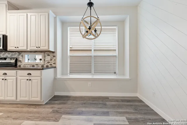 a view of kitchen with granite countertop cabinets and window