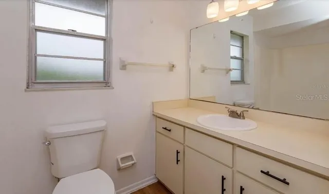 a bathroom with a toilet sink and mirror