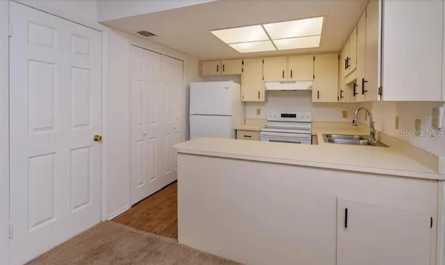a kitchen with a sink a refrigerator and cabinets