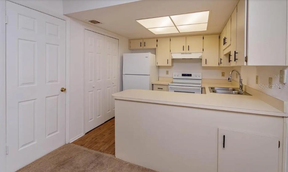 68 Windtree Lane, Unit 201 Winter Garden, FL 34787 - Photo 8 of 23 a kitchen with a sink a refrigerator and cabinets