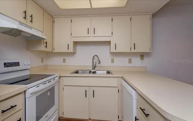 a kitchen with white cabinets and white appliances