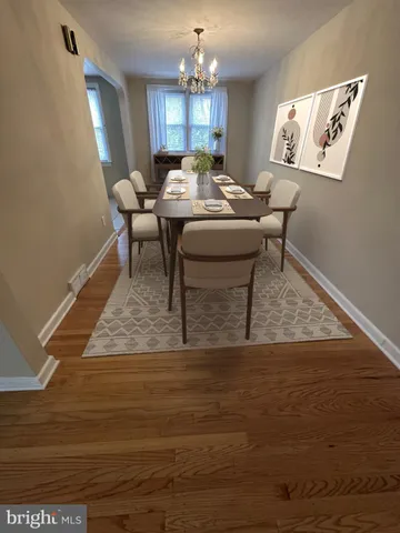 a living room with table chairs and a wooden floor