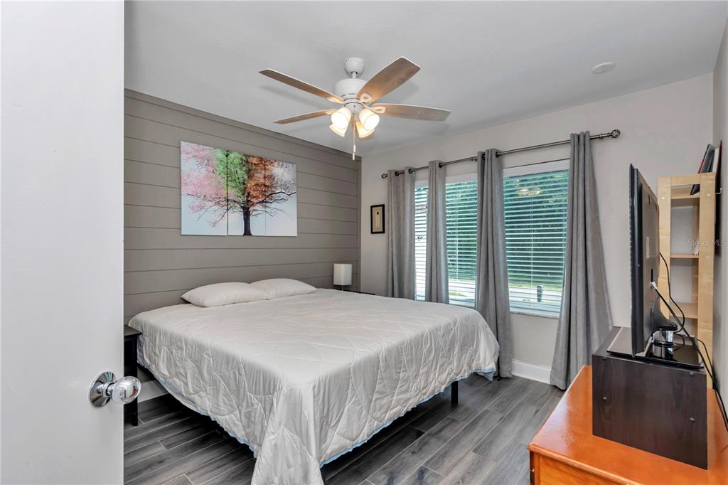 814 Oak Road Ocala, FL 34472 - Photo 37 of 52 a bedroom with a bed a dresser and wooden floor