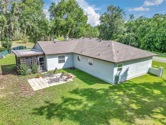 a aerial view of a house with a yard table and chairs