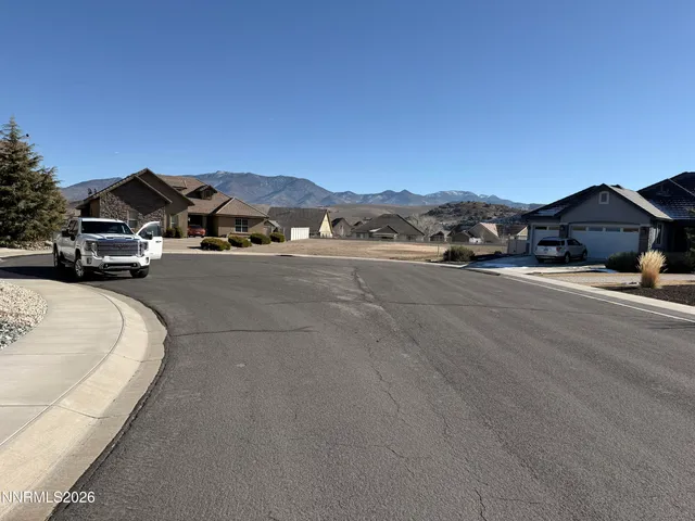 a view of a car parked in front of a house with a road
