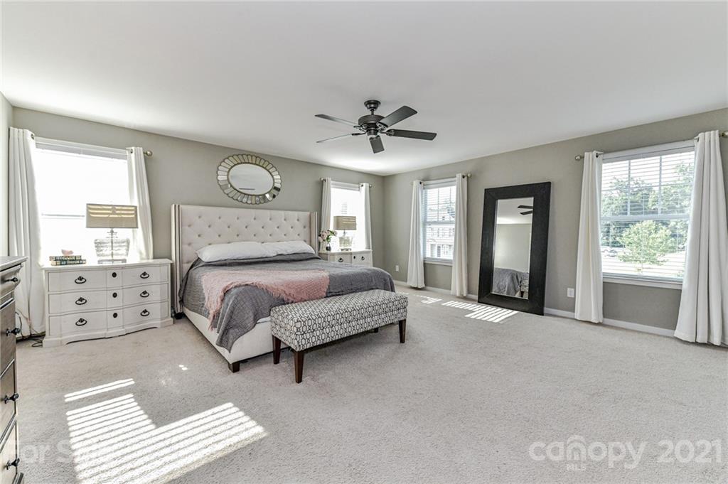 8074 Bryson Road Indian Land, SC 29707 - Photo 29 of 46 a spacious bedroom with a bed and a chandelier