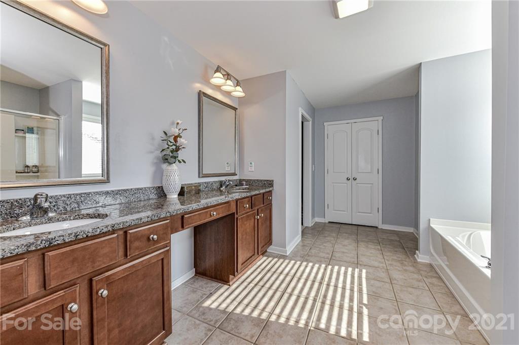 8074 Bryson Road Indian Land, SC 29707 - Photo 31 of 46 a spacious bathroom with a granite countertop double vanity sink a mirror and a