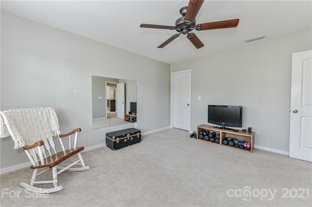 8074 Bryson Road Indian Land, SC 29707 - Photo 34 of 46 a living room with furniture a flat screen tv and a ceiling fan