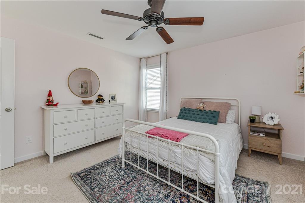 8074 Bryson Road Indian Land, SC 29707 - Photo 39 of 46 a bedroom with a bed a chandelier and dresser