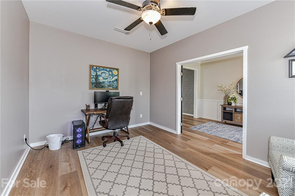 8074 Bryson Road Indian Land, SC 29707 - Photo 8 of 46 a workspace with wooden floor and a chandelier fan
