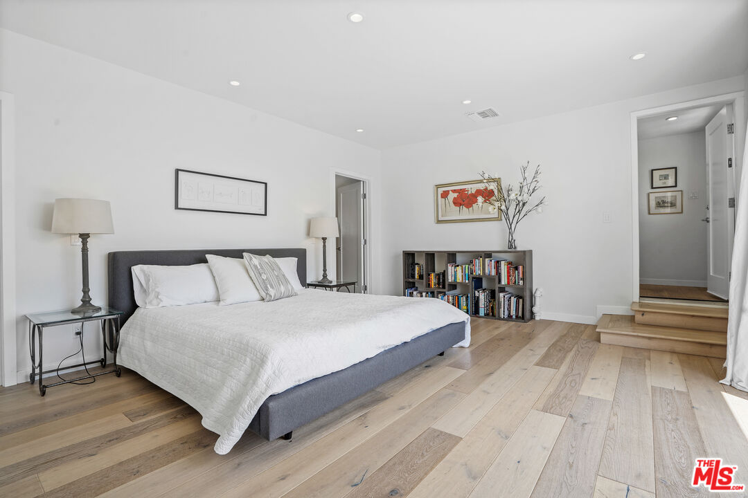 27861 Winding Way Malibu, CA 90265 - Photo 21 of 36 a spacious bedroom with a bed and a wooden floor