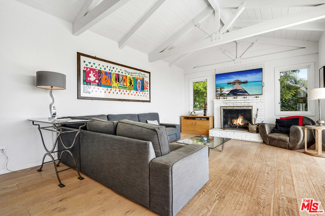 27861 Winding Way Malibu, CA 90265 - Photo 3 of 36 a living room with furniture a fireplace and a flat screen tv