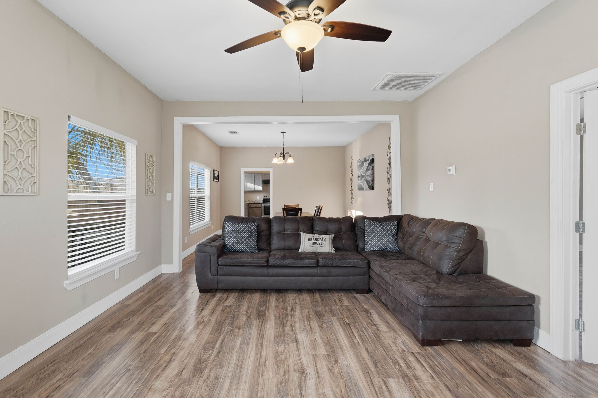 308 East Phillips Street Conroe, TX 77301 - Photo 7 of 36 a living room with couches and kitchen view with wooden floor