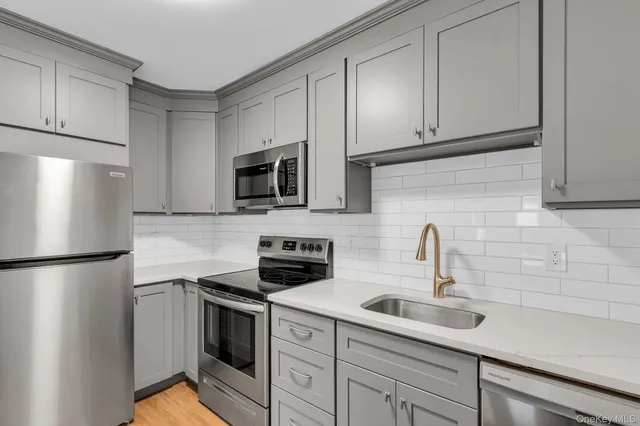 a kitchen with stainless steel appliances a refrigerator sink and cabinets