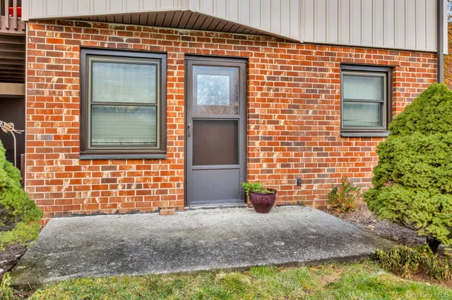 a view of a porch with a floor to ceiling window and potted plants