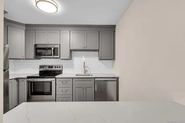 a kitchen with stainless steel appliances granite countertop a stove a sink and a microwave