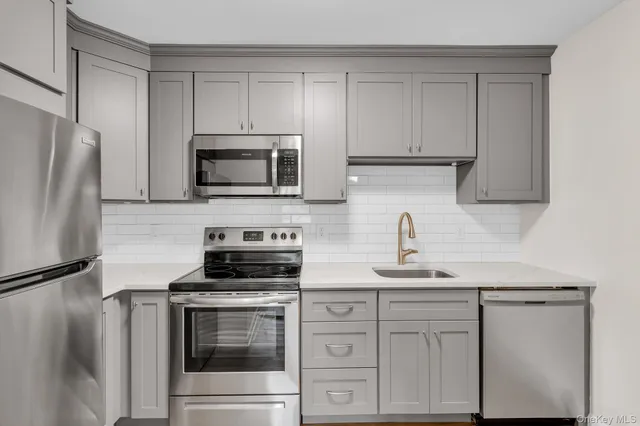 a kitchen with white cabinets and stainless steel appliances