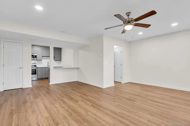 a view of empty room with wooden floor and window