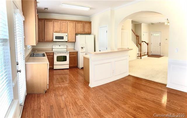 1140 Hammond Drive Matthews, NC 28104 - Photo 6 of 17 a kitchen with white cabinets and wooden floor