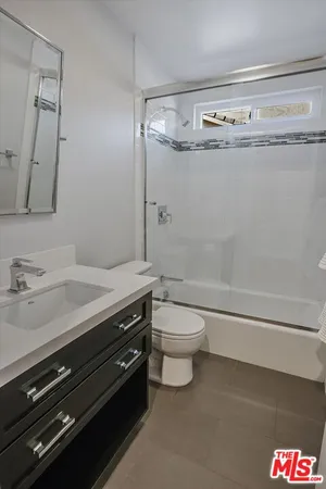 a bathroom with a granite countertop toilet and a sink