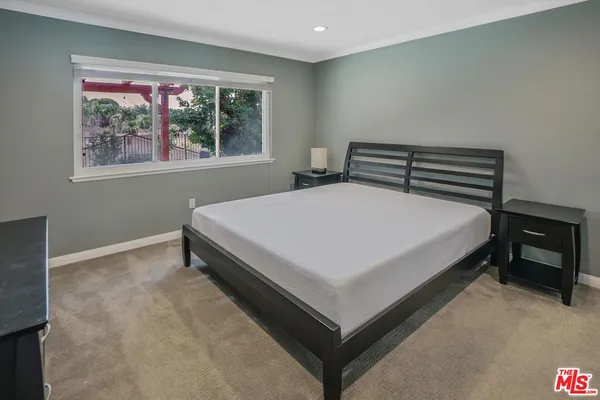 a bed sitting in a bedroom next to a window