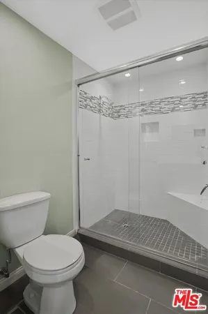 a bathroom with a toilet and a shower