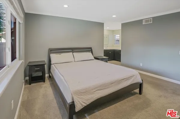 a large bed sitting in a bedroom next to a window