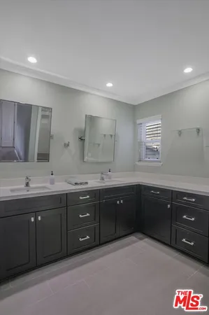 a spacious bathroom with a granite countertop double vanity and a large mirror