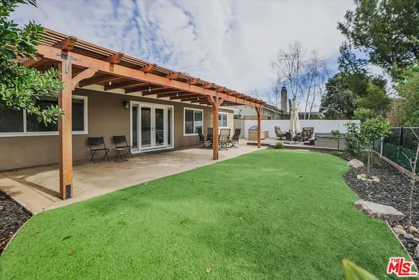 a view of a house with a backyard and a patio