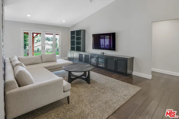 a living room with furniture and a hard wood floor