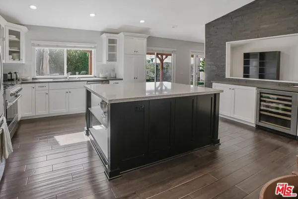 a kitchen with a sink cabinets and wooden floor