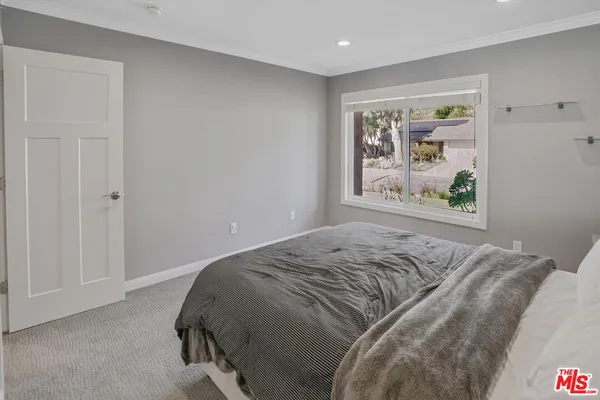 a bed sitting in a bedroom next to a window