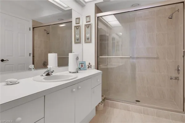 a bathroom with a shower sink and mirror