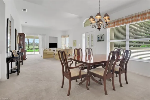 a view of a dining room with furniture and chandelier