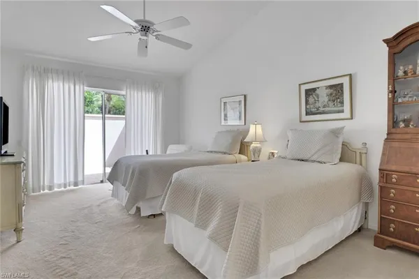 a spacious bedroom with a bed and a flat screen tv