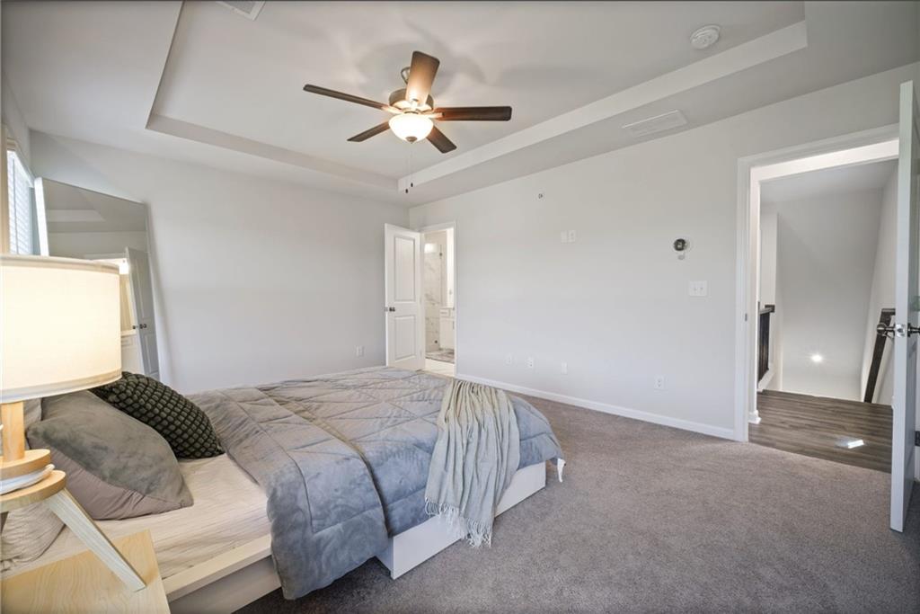 1595 Ridgebrook Downs Mableton, GA 30126 - Photo 18 of 39 a spacious bedroom with a bed and a chandelier